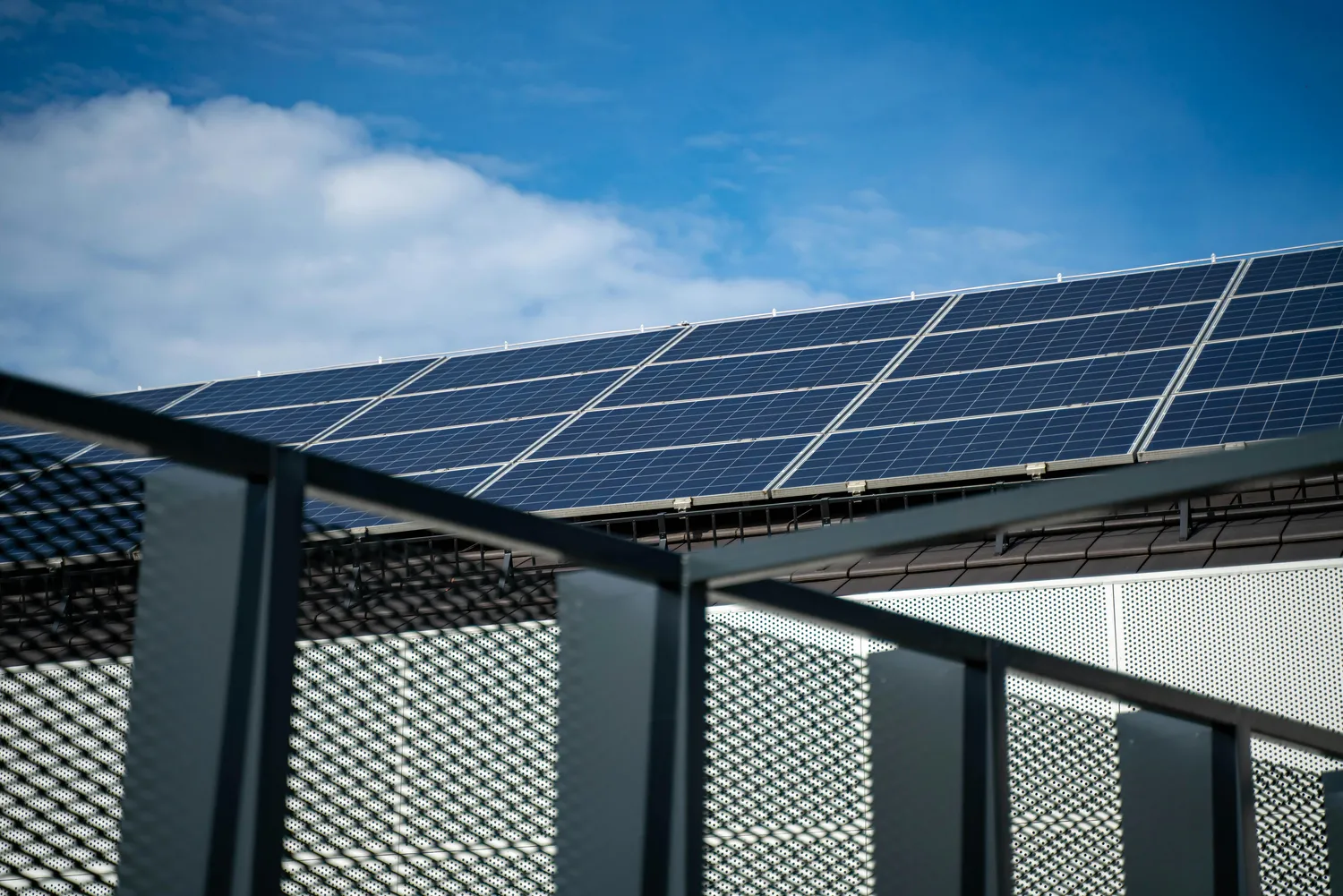 FK Systems GmbH - Technologie solaire - Équipe d'ouvriers installant des panneaux photovoltaïques sur le toit d'un bâtiment, emplois dans le secteur des énergies renouvelables